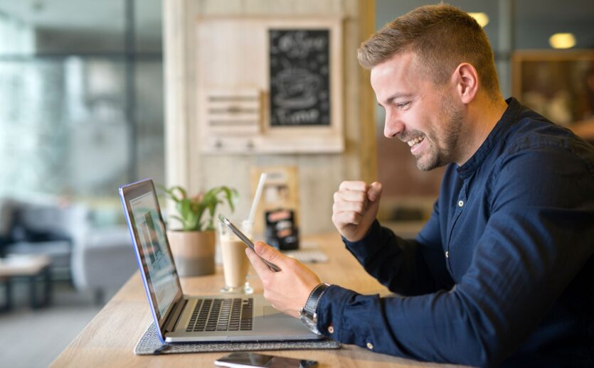 happy-freelancer-with-tablet-laptop-computer-coffee-shop